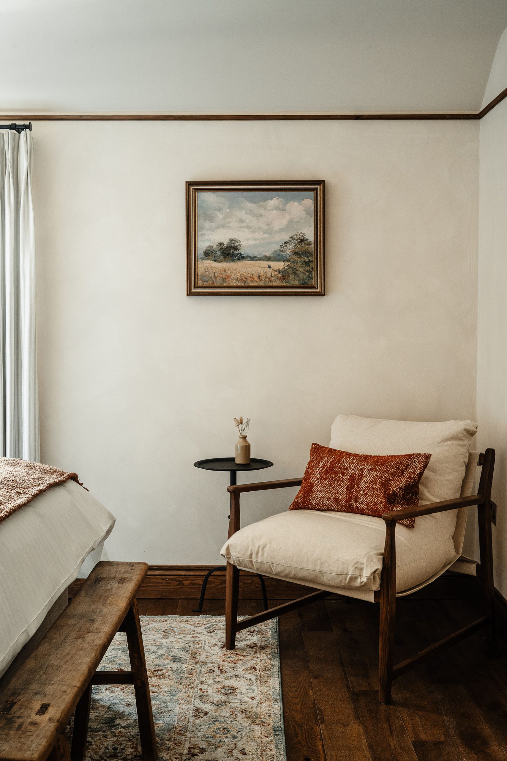 Image of a bedroom at The General Tarleton showing a comfortable cream armchair with red cushion by a window