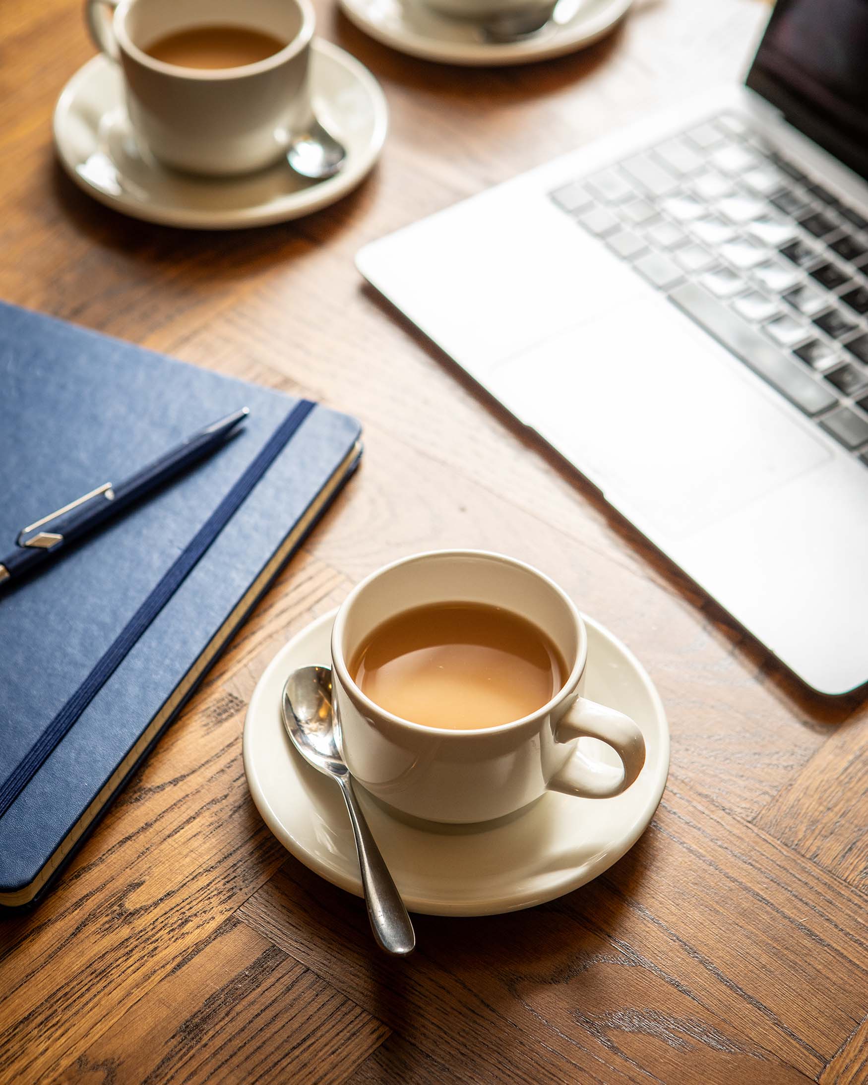 Image of a cup of coffee, laptop and note book depicting an away day at The General Tarleton