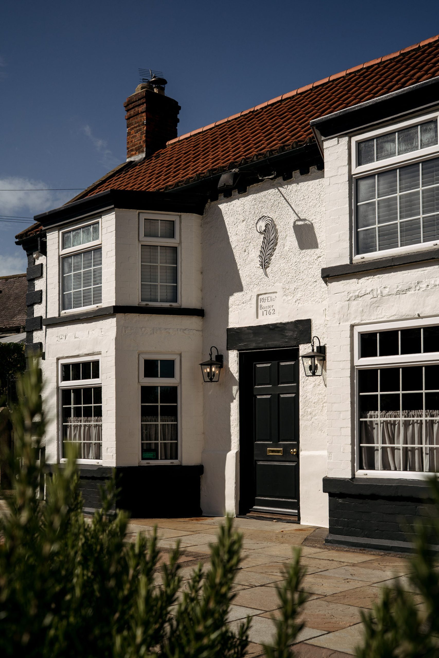 Image showing the exterior of The General Tarleton, a white building with red roof and feather logo above the door