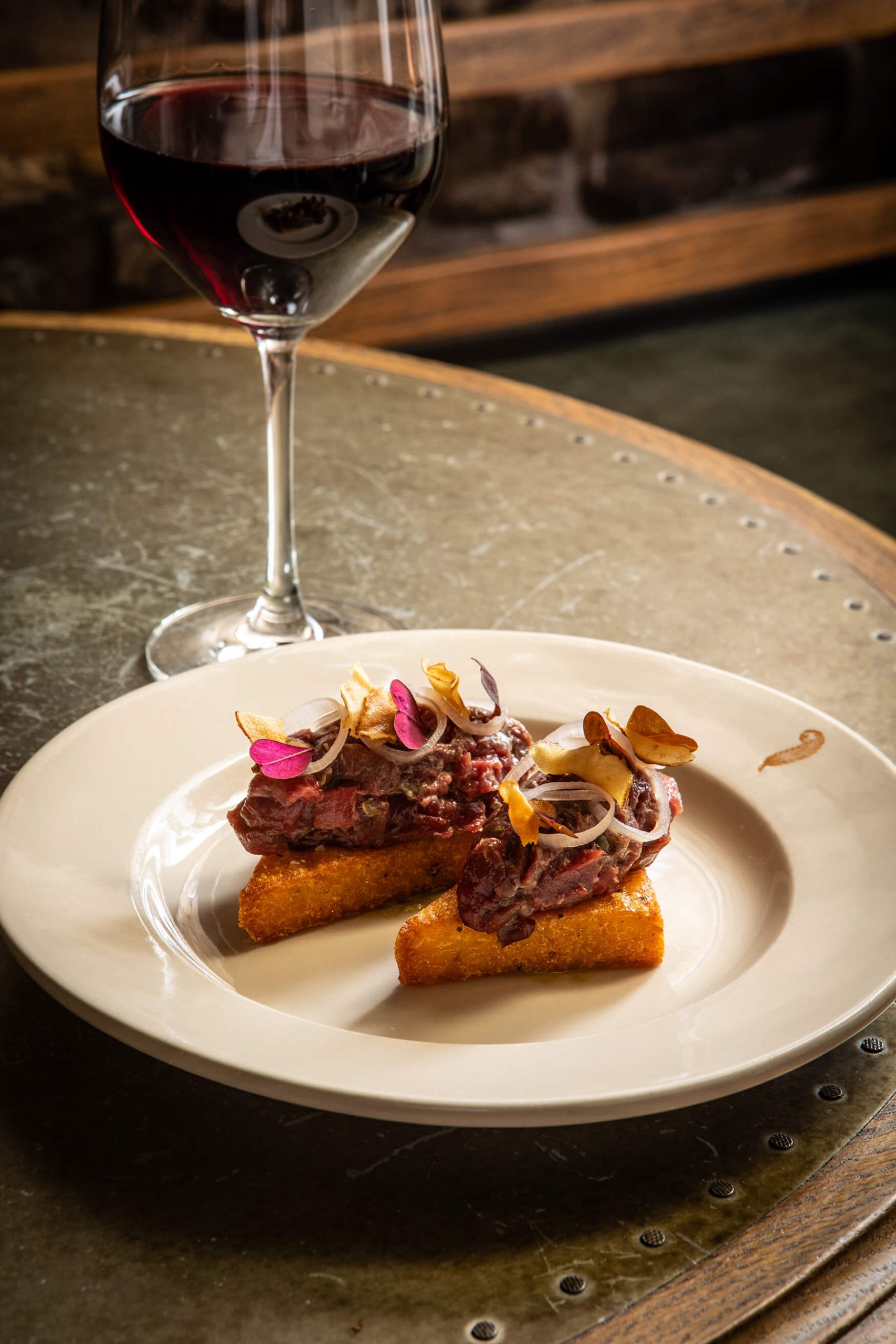 Steak tartare on a branded General Tarleton plate with a glass of red wine