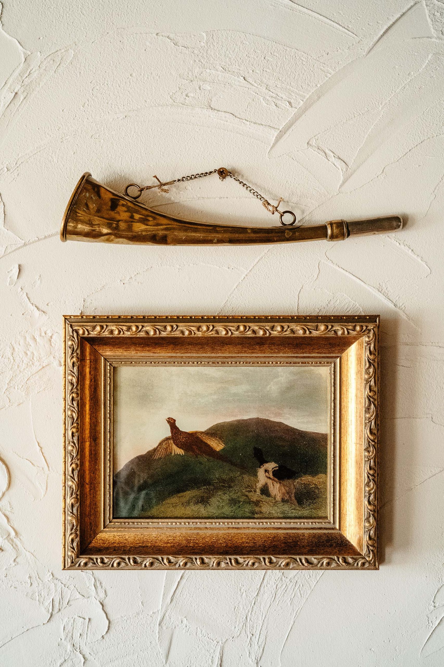 Image showing a picture of a pheasant in a gold frame and a horn hanging on a white wall in the bar at The General Tarleton