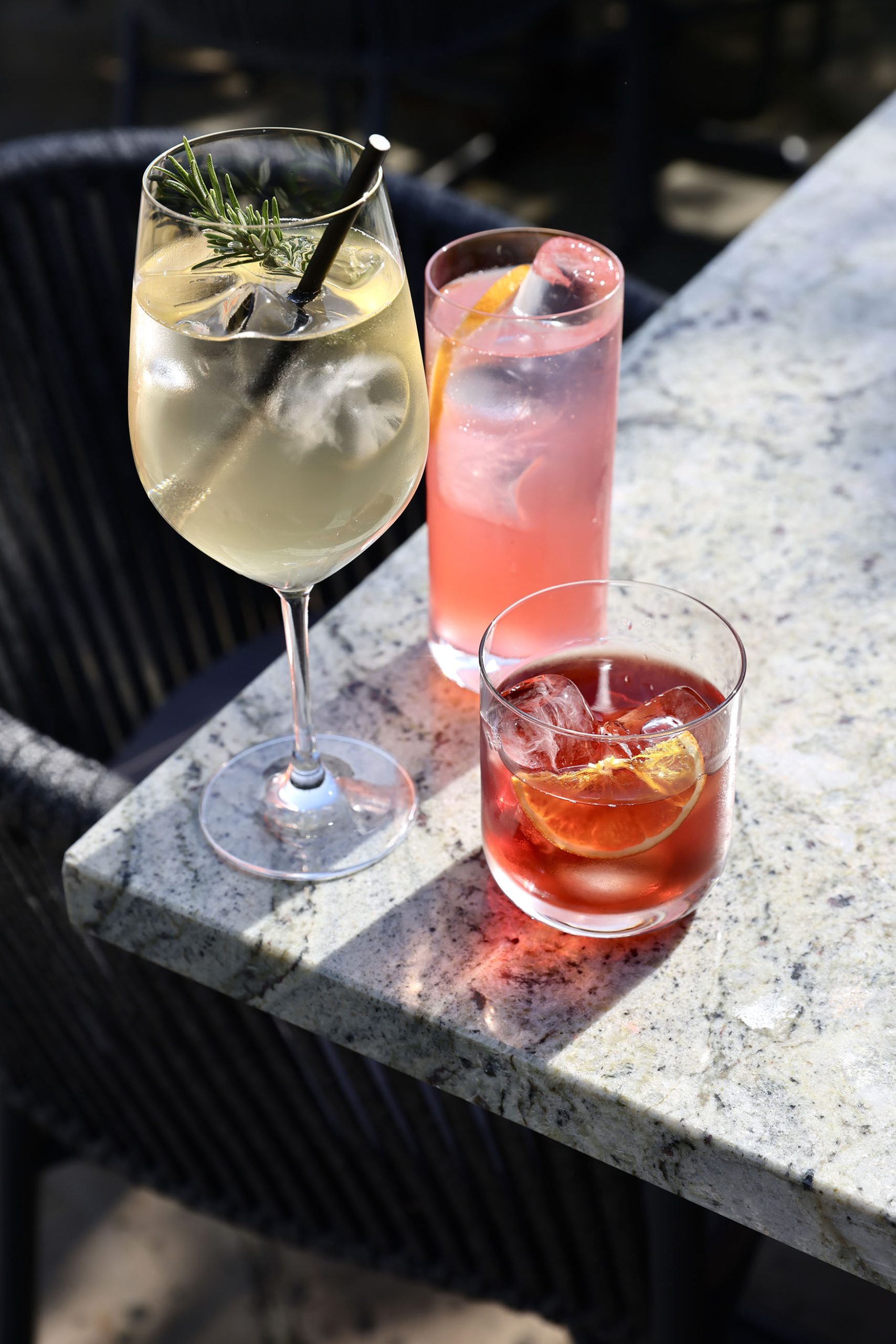 Image showing three cocktails sitting on a table outiside in the sunshine