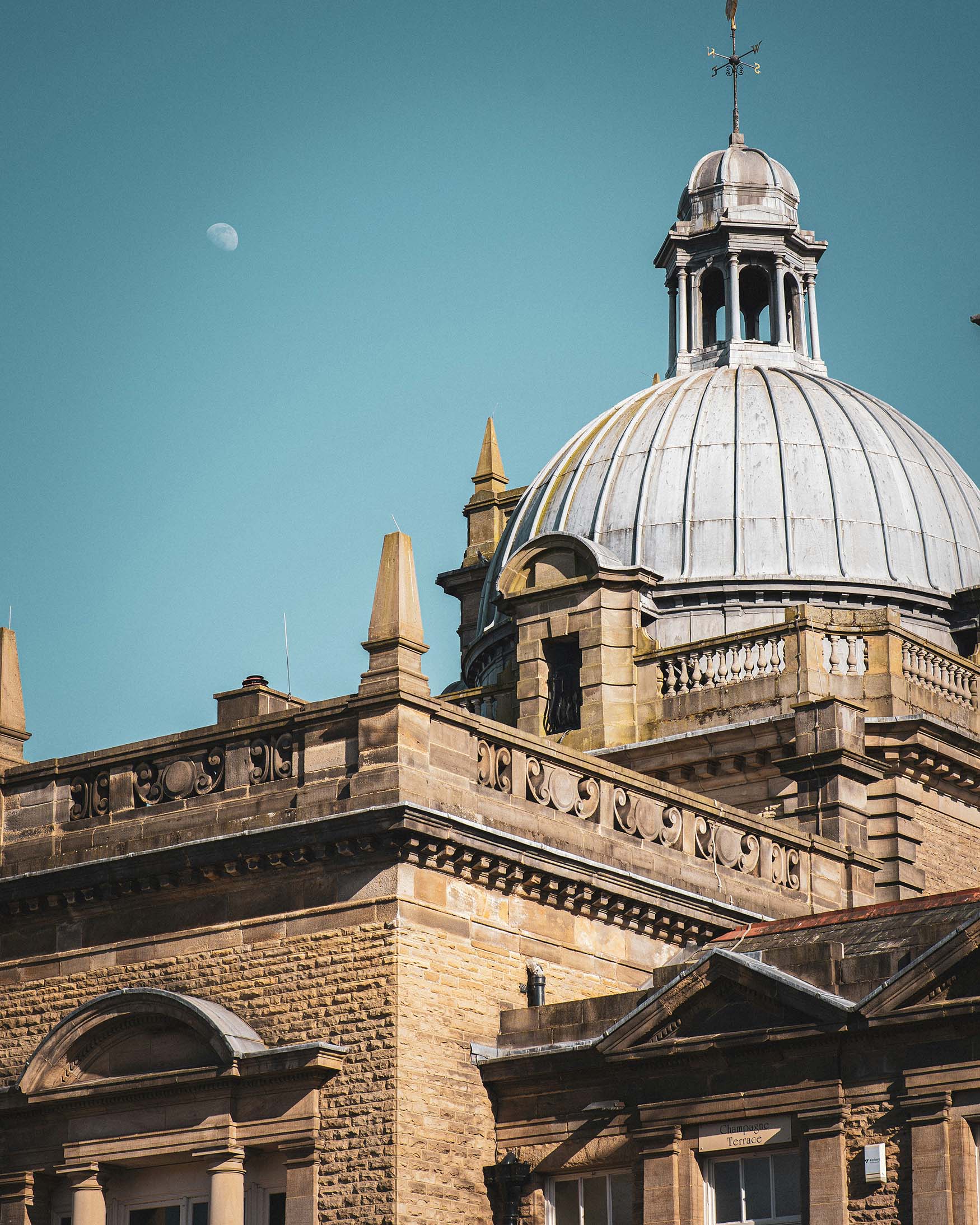 Image of a classical building with a domed roof and blue sky