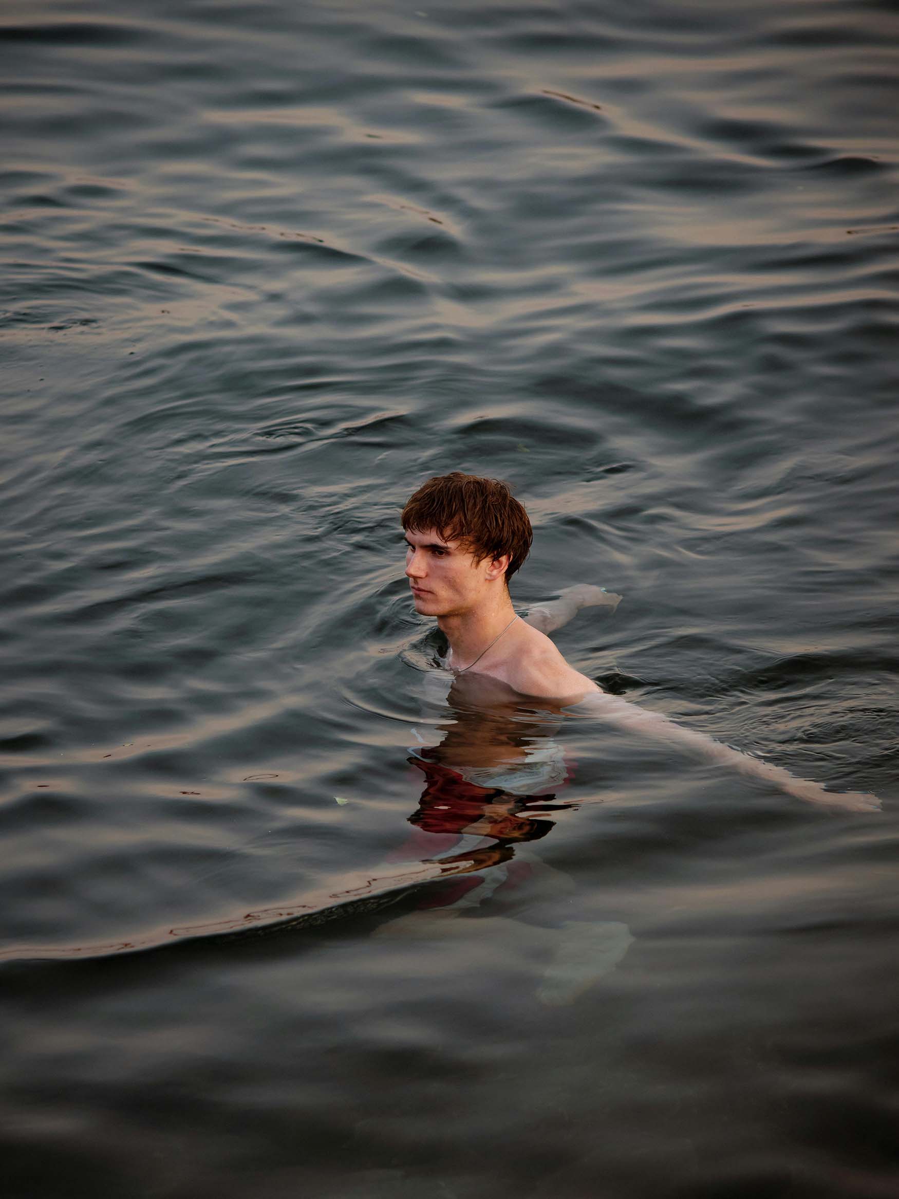 Man swimming in a lake depicting wellness and wind down