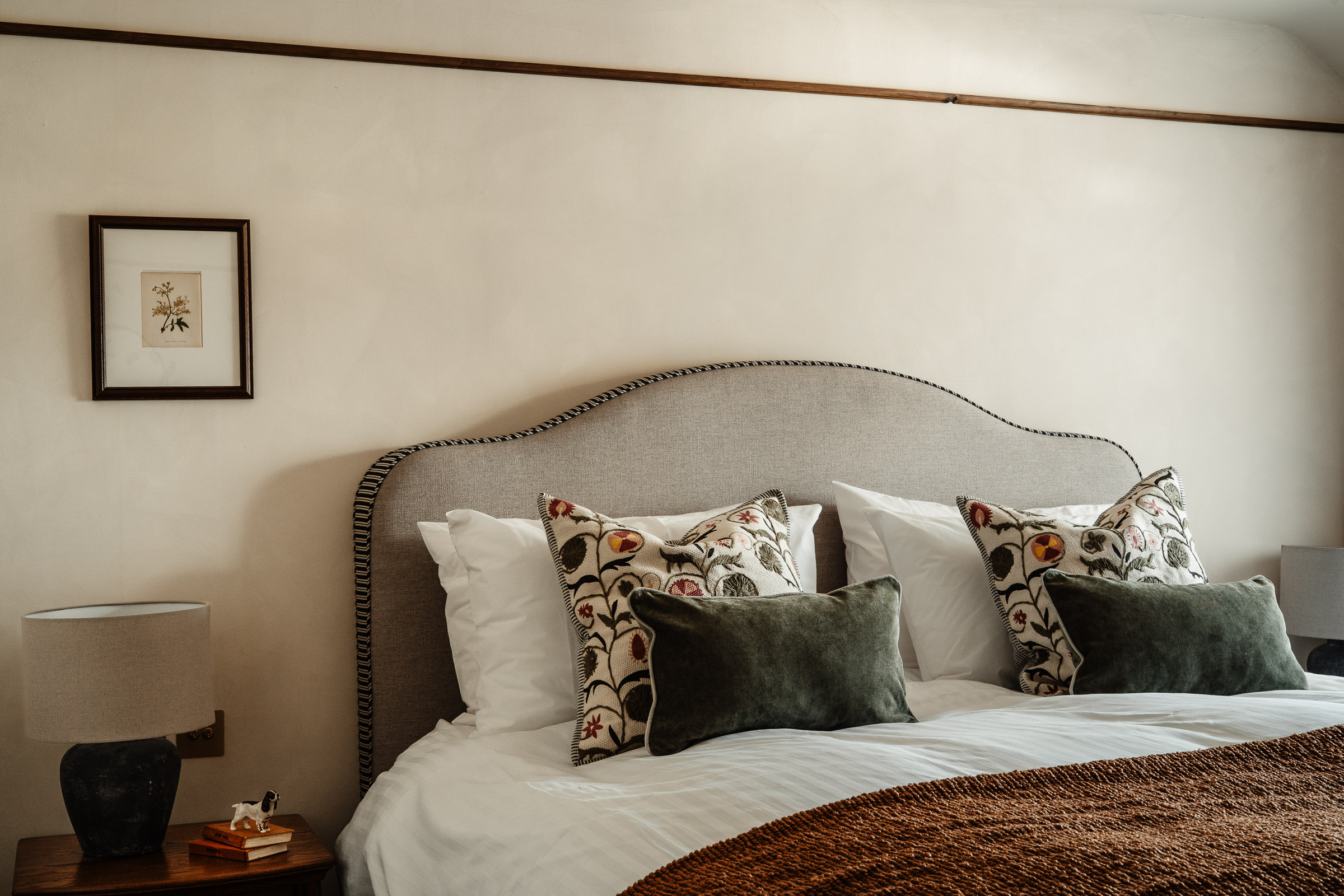 Image showing a hotel bedroom at The General Tarleton with orange throw and green pillows